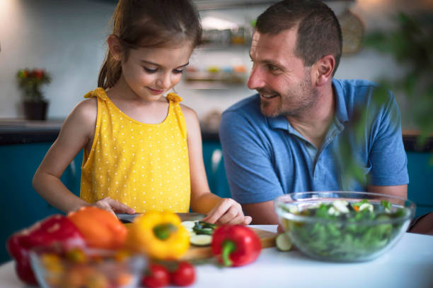 istock Father and daughter making salad together 1488954753