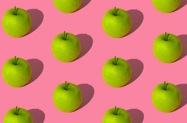 istock Trendy fruit pattern made of green apples on light pastel pink background. Minimal layout. Nature summer concept. 1488956838
