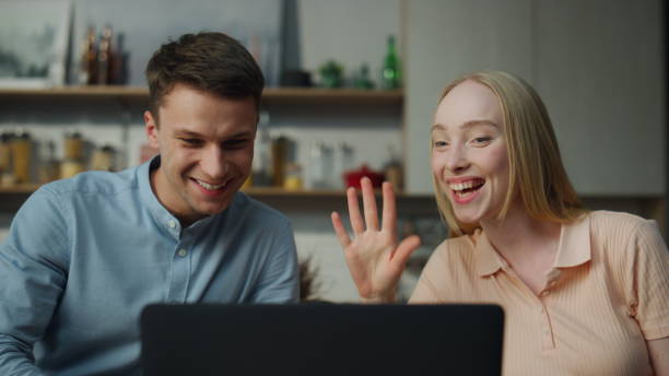 istock Married couple chatting online on video call from home sitting kitchen close up. 1488957710