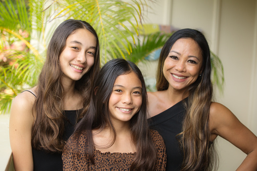 Family portrait of a Hawaiian family, with mother and two teen girls.