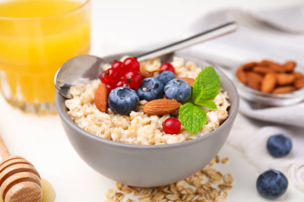 istock Oatmeal served with berries, almonds and mint on white table, closeup 1488958172