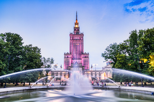 Illuminated Palace of Culture and Science with Fountain at Dusk in Warsaw, Poland