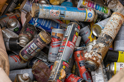Spray cans, spray paint and aerosol cans in pile to be recycled.