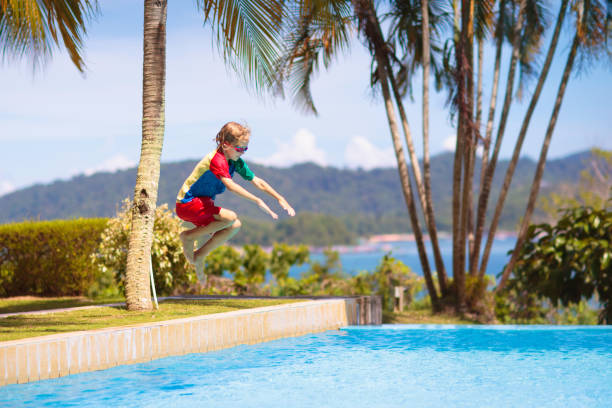 istock Kids jump into swimming pool. Summer water fun. 1488963643
