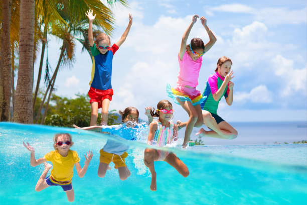 istock Kids jump into swimming pool. Summer water fun. 1488963844
