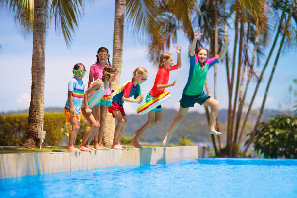 istock Kids jump into swimming pool. Summer water fun. 1488964048