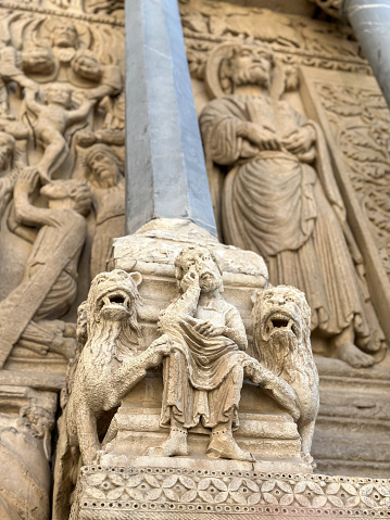 Fragment of facade of Saint Trophime catholic church build in 12th century. Sculptures of saints and majestic animals over the church portal. Details of the west portal Saint Trophime Cathedral in Arles, France. Bouches-du-Rhone, France