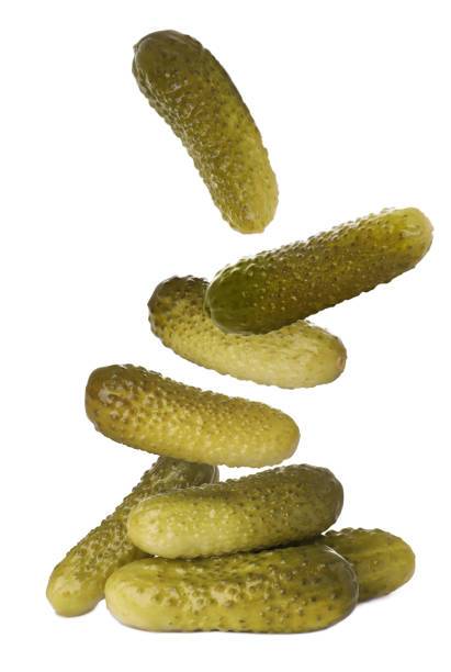 istock Tasty pickled cucumbers falling into pile on white background 1488970632
