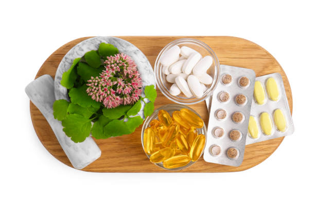 istock Board with mortar, fresh herbs and pills on white background, top view 1488971170