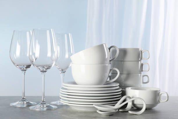 istock Set of clean dishware and glasses on grey marble table 1488971249