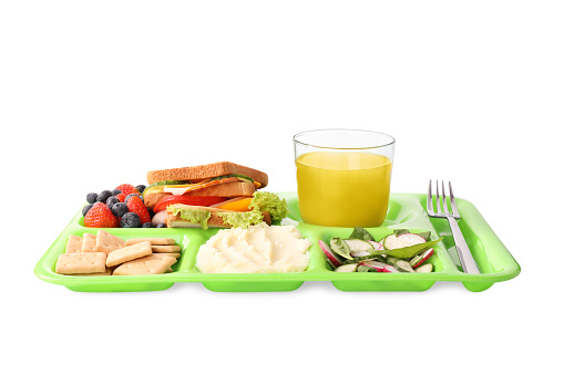 Serving tray with tasty healthy food and juice isolated on white. School dinner