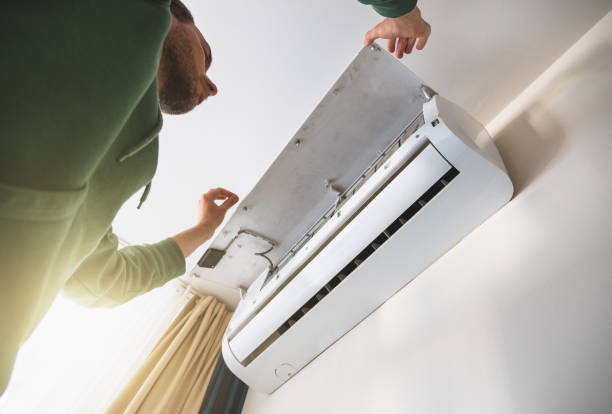 istock Worker cleans air conditioner. Maintenance of cooling systems before summer season 1488972612