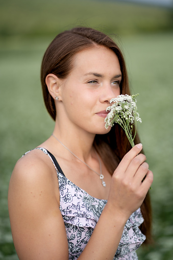 Woman enjoying the scent of a wild flower