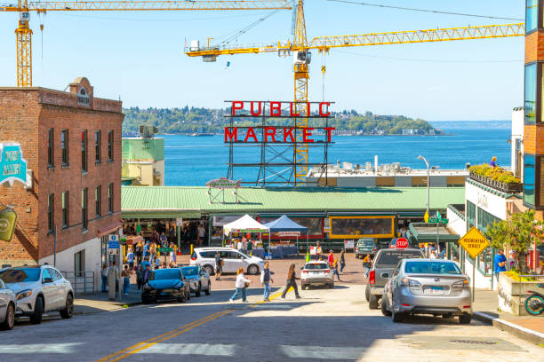 turyści tłoczą się na ulicach miasta poniżej głównego znaku nad pike's place public market wzdłuż portu nabrzeżnego podczas zaplanowanych remontów ulic trwających w centrum seattle w stanie waszyngton. - pike place market market seattle tourist zdjęcia i obrazy z banku zdjęć