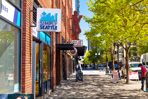 View of the Simple Seattle tourism and souvenir store and Seattle Coffee Works in the downtown district along the waterfront at Seattle, Washington USA