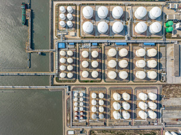 istock Many neatly arranged large cylindrical storage tanks by the seaside 1488977013