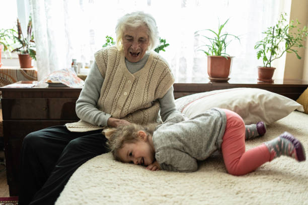 Grandmother showing her granddaughter how to embroider using a cross-stitch technique, passing down traditional skills and creating a bonding moment