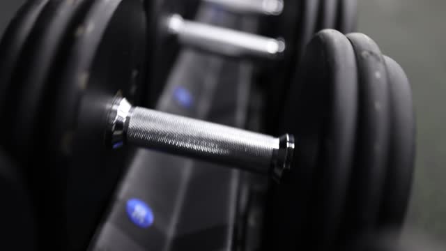 Lot of dumbbells lying neatly in row in gym closeup 4k movie slow motion