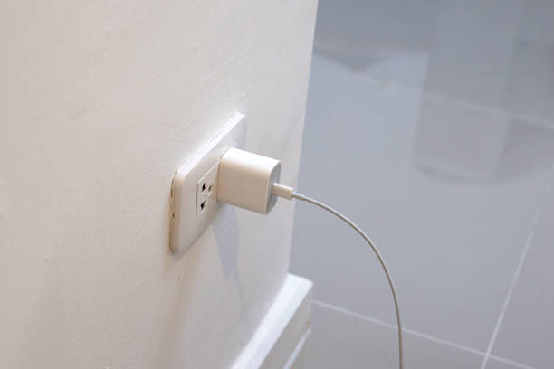 istock Hand insert a plug of the phone charger into socket. 1489010939