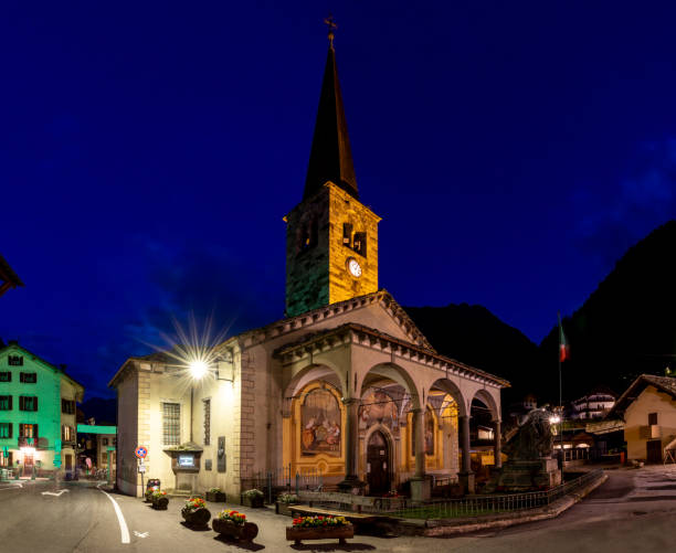 Alagna - The church Chiesa di San Giovanni Battista in the Valsesia valley range at dusk - Italy. Alagna - The church Chiesa di San Giovanni Battista in the Valsesia valley range at dusk - Italy. alagna stock pictures, royalty-free photos & images