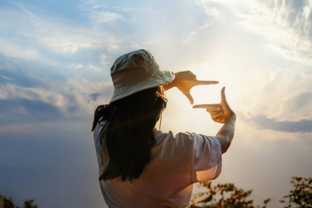 istock Woman Hands framing view distant over sunrise. Woman making frame round the view with her hands in sunset, Future planning idea concept. business concept. New year planning and vision concept 1489014272