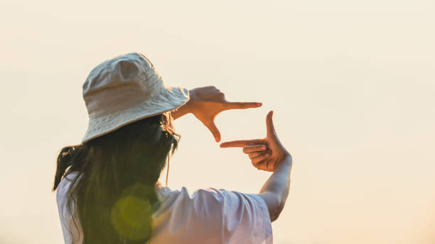istock Woman Hands framing view distant over sunrise. Woman making frame round the view with her hands in sunset, Future planning idea concept. business concept. New year planning and vision concept 1489014906