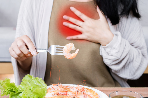 woman having difficulty breathing after eating shrimp ,symptoms of seafood allergy