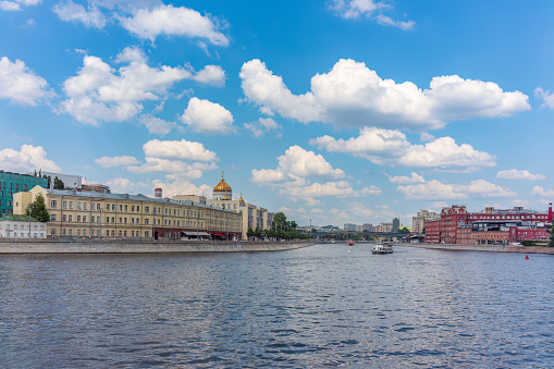 Cruise ship sails on the Moscow river in Moscow city center, popular place for walking. Panoramic view of Moscow river with cruise boat