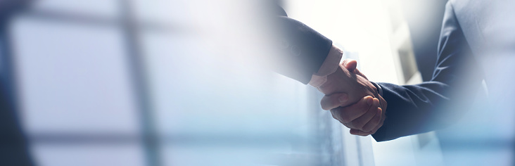 Businessmen making handshake with partner, greeting, dealing, merger and acquisition, business cooperation concept, panoramic banner, copy space for business, finance and investment background