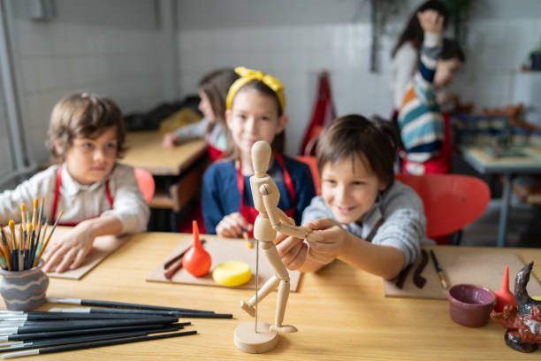 istock Children playing with a wooden puppet during art class 1489034587