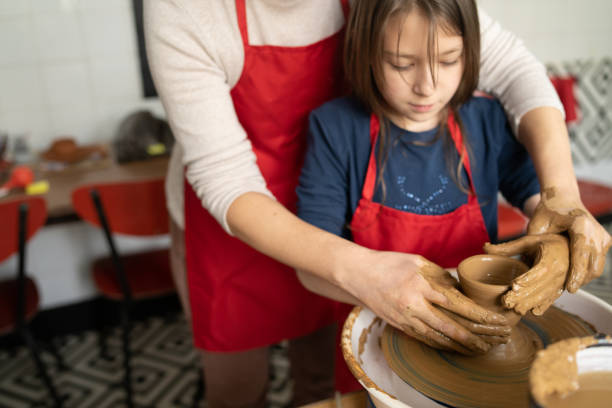 istock A teacher helping her pupil with a potters wheel 1489034595