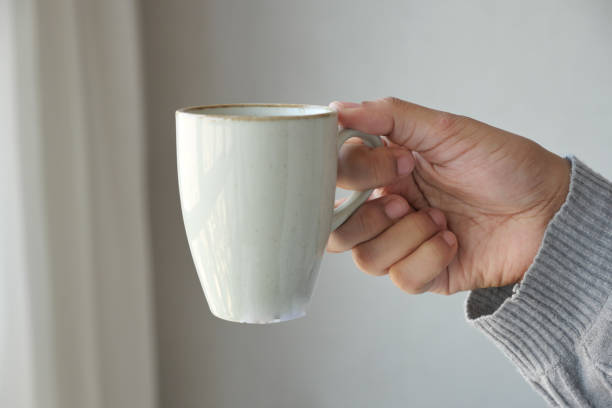 istock Close up of women's hand holding coffee mug 1489038334