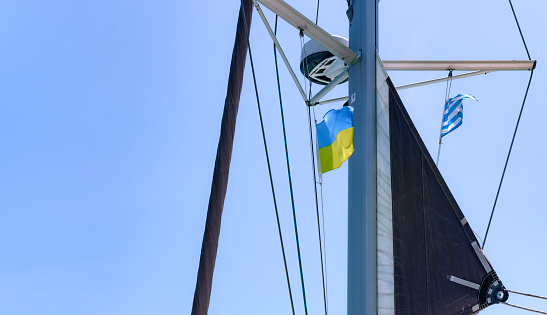 Ukrainian and Greek flags on mast of the sailing boat