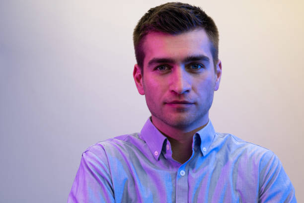 istock A man in a shirt poses on a dark multicolored neon background 1489042255