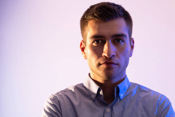 istock A man in a shirt poses on a dark multicolored neon background 1489043573