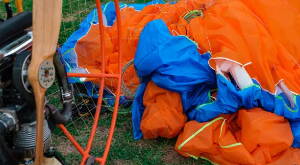 Photo of paragliding open parachute in pile and paraglide wooden propeller motor, after flight