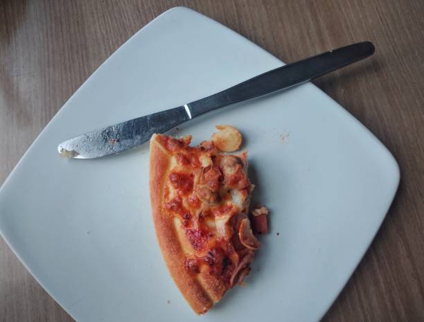 istock Slice of pizza on plate with knife 1489048953