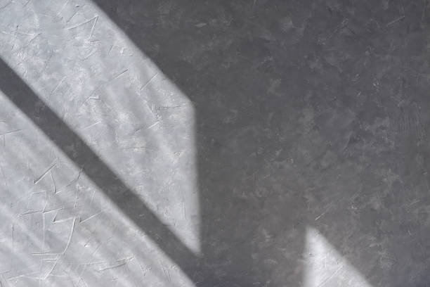istock Empty gray concrete wall texture with geometric window silhouette sun light shadow, home room interior template, background 1489050433