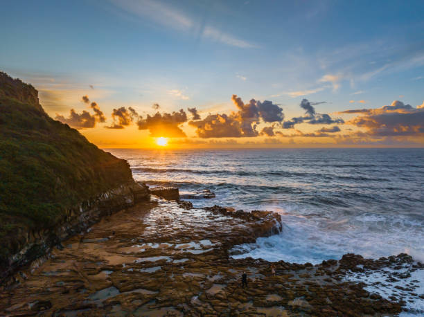 istock Sunrise and clouds over the ocean and rock platform 1489050515