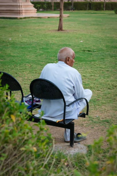 istock old man isolated sitting alone at iron chair at park from back at evening 1489052017