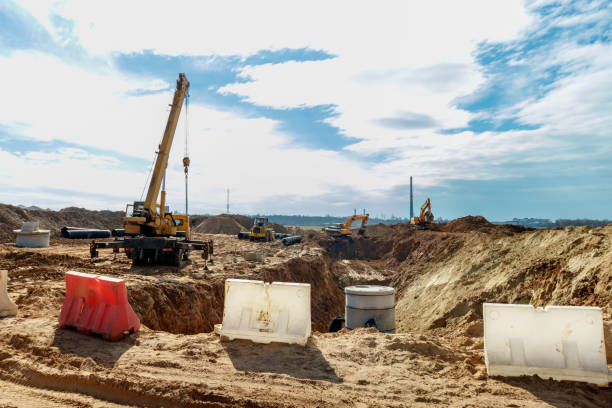 istock Connecting a trench drain to a concrete manhole structure at construction site. Concrete pile in formwork frame for construct stormwater and underground utilities, pump stations, sewers pipes 1489056086