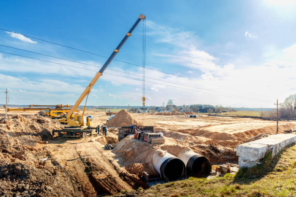 Connecting a trench drain to a concrete manhole structure at construction site. Concrete pile in formwork frame for construct stormwater and underground utilities, pump stations, sewers pipes Connecting a trench drain to a concrete manhole structure at construction site. Concrete pile in formwork frame for construct stormwater and underground utilities, pump stations, sewers pipes. public utility stock pictures, royalty-free photos & images