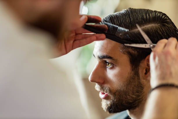 istock Young man having a haircut at barber shop. 1489056471