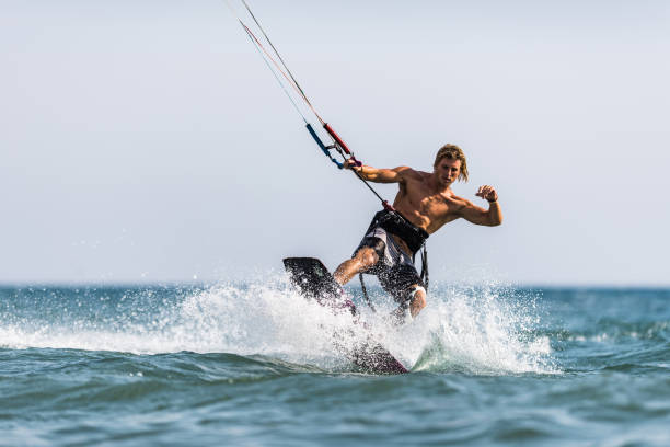 istock Young man enjoying in kiteboarding during summer day at sea. 1489057793