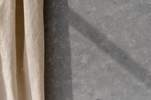 istock Empty gray concrete wall texture and beige linen curtain, minimalist neutral interior design background, home room backdrop with sun light shadow 1489058234
