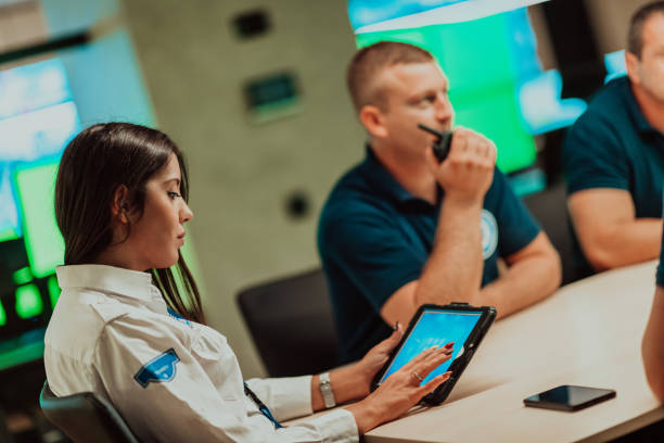 istock Group of security guards sitting and having briefing In the system control room They're working in security data center surrounded by multiple Screens 1489058488