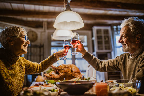 istock Happy senior couple toasting on Thanksgiving lunch at dining table. 1489058694