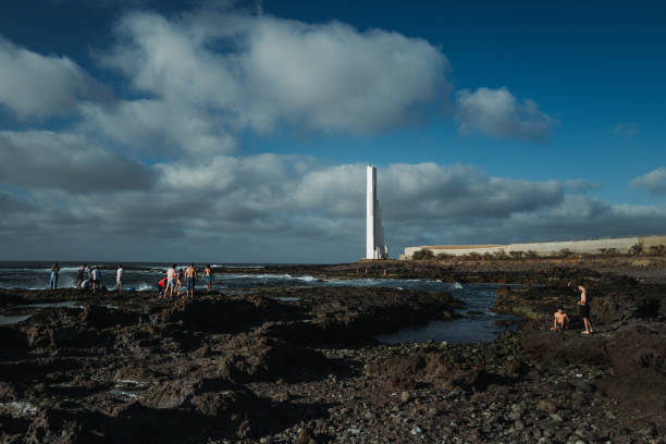 Punta del Hidalgo, Spain, April 5, 2023: People by the sea at sunset on April 5, 2023 in Punta del Hidalgo, Tenerife, Canary Islands, Spain. People enjoy a warm spring sunset in Punta del Hidalgo coastline.