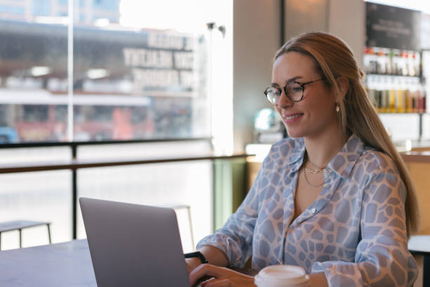 istock Young woman using laptop in a coffee shop 1489062248