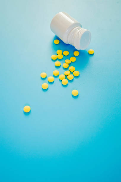 istock Yellow pharmaceutical drugs, pills with a bottle on a blue background. Copy space for text 1489062284